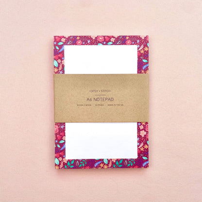 Floral notepad with a brown kraft cover on a pink background