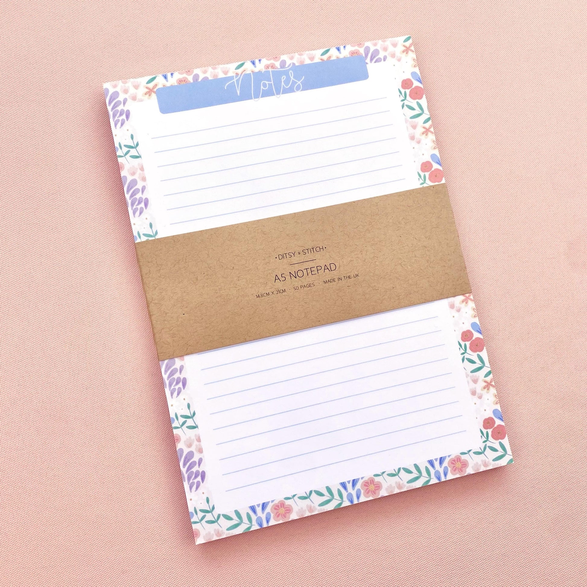 Floral border notepad on a pink background
