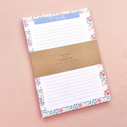 Floral border notepad on a pink background