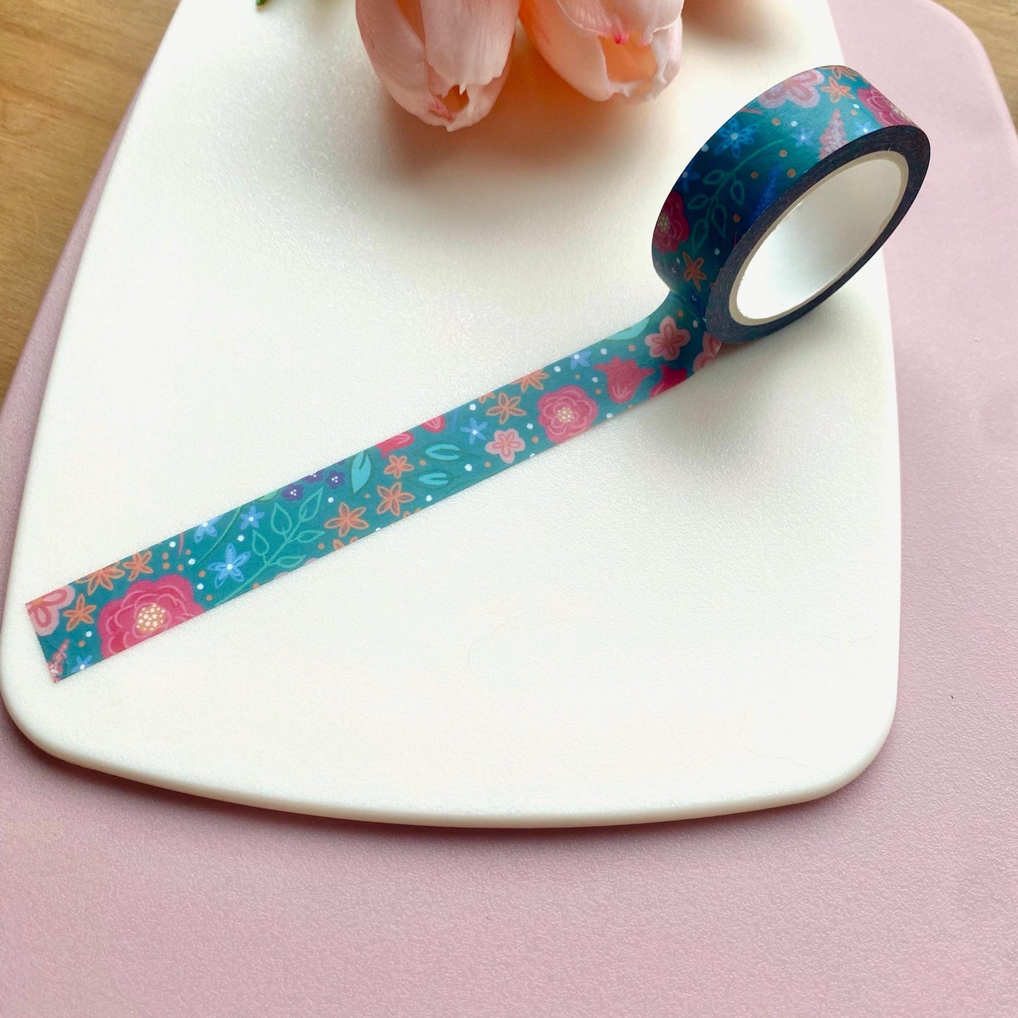 Roll of decorative tape with floral pattern on a white surface