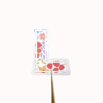 Letter 'L' shaped sticker with floral design on a white background