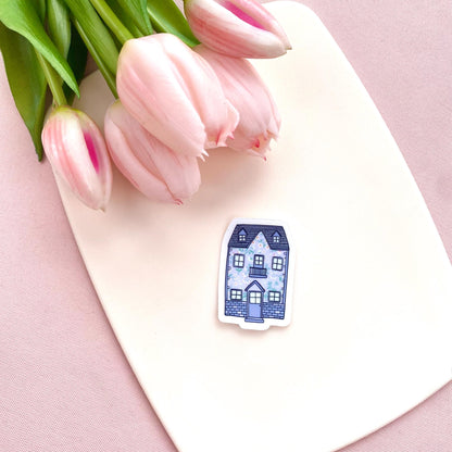 Blue floral patterned house sticker on a cream background with pink tulips.