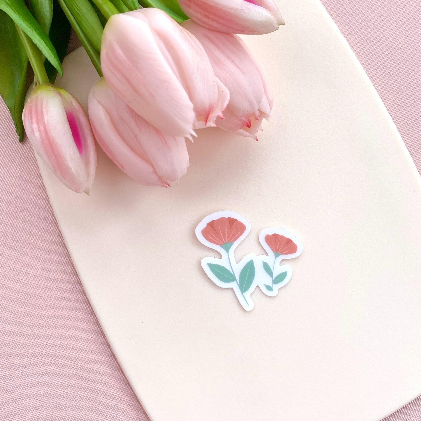 Pink flowers sticker against a cream background with pink tulips.