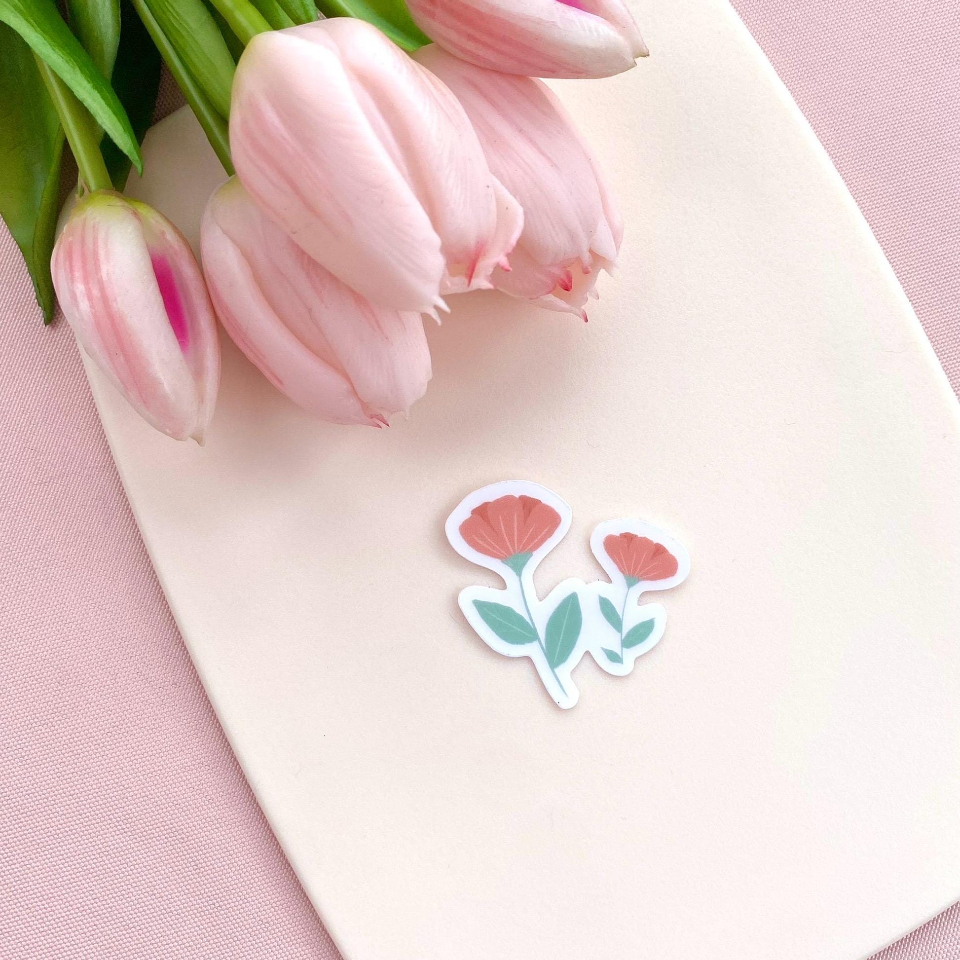 Pink flowers sticker against a cream background with pink tulips.
