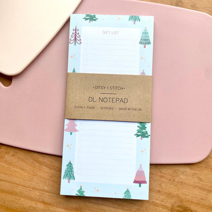 Notepad with Christmas tree design on a pink surface