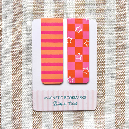 Two colourful magnetic bookmarks with pink and orange checkerboard and striped patterns on a card with 'Ditsy & Stitch' branding against a striped background.